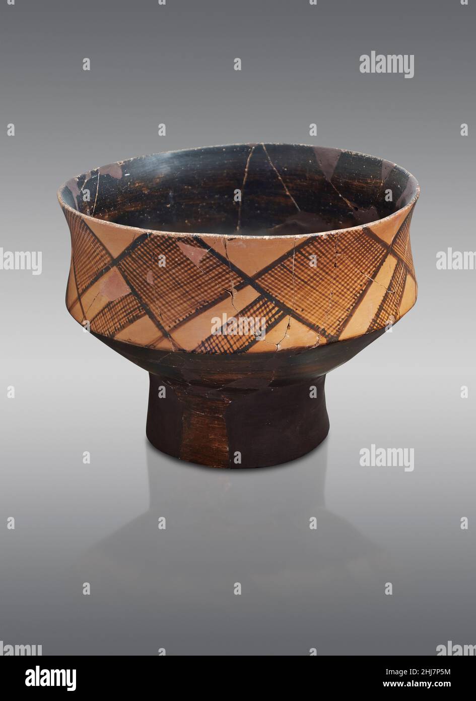 Ancient Helladic Greek pottery fruit stand with black base and geometric patterns, Tiryns, 5800-5300 BC. Nafplion Archaeological Museum.: Against grey Stock Photo