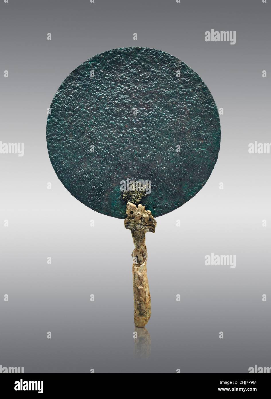 Mycenaean pottery - Bronze mirror with ivory handle, 1500 - 1350 BC, Mycenaean cemetery of Asine. Nafplion Archaeological Museum.  Against grey backgr Stock Photo