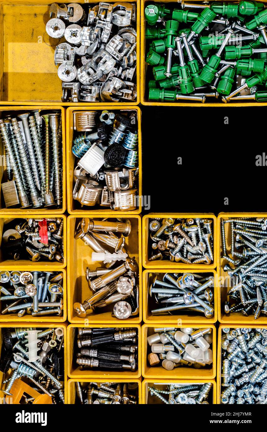Yellow case with small construction objects. Many storage compartments filled with builders accessories Stock Photo