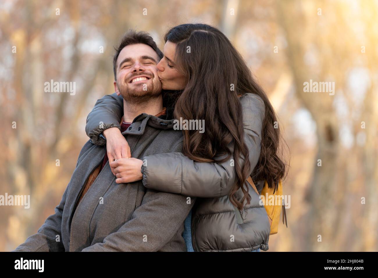 Young heterosexual couple kissing in a park on valentine's day Stock Photo