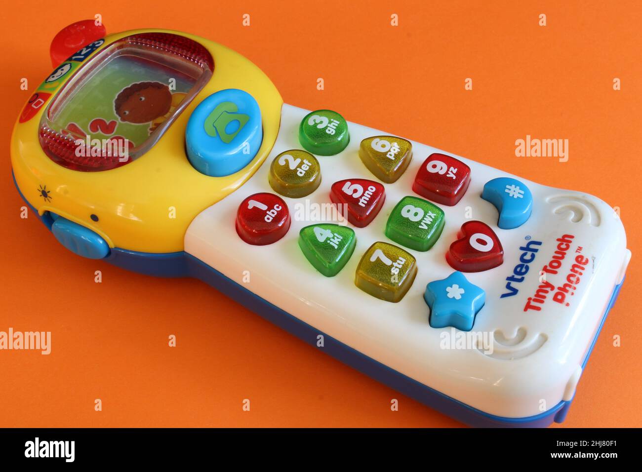 Vtech toy phone isolated on an orange background. Lancashire, UK, 27-01-2022 Toddler toys and cognitive development concept Stock Photo