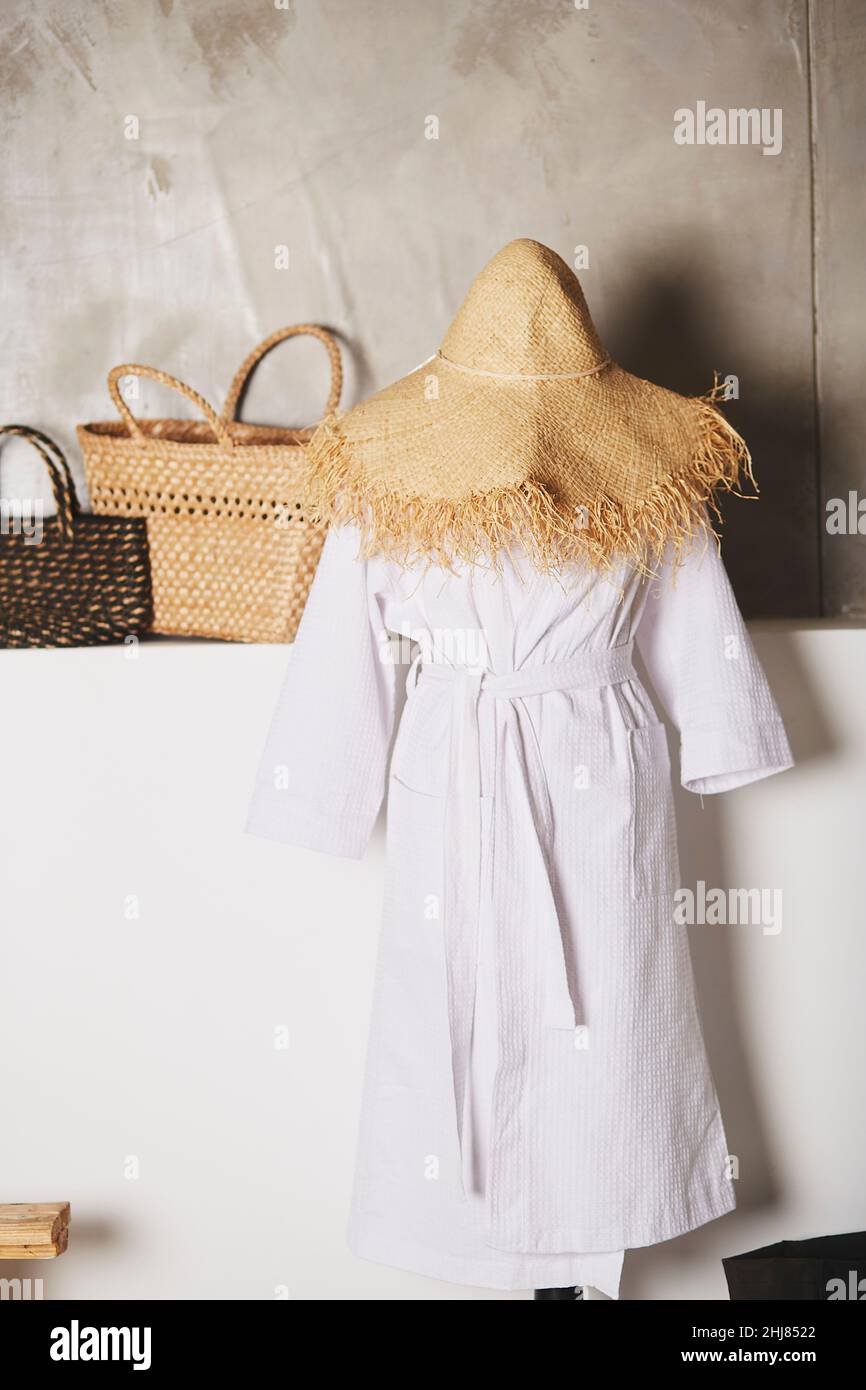 Straw Robe Mannequin in robe and straw hat. Straw wicker bags on the background ...