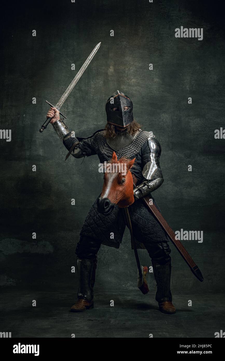 Portrait of medieval warrior or knight wearing helmet and armor riding ...
