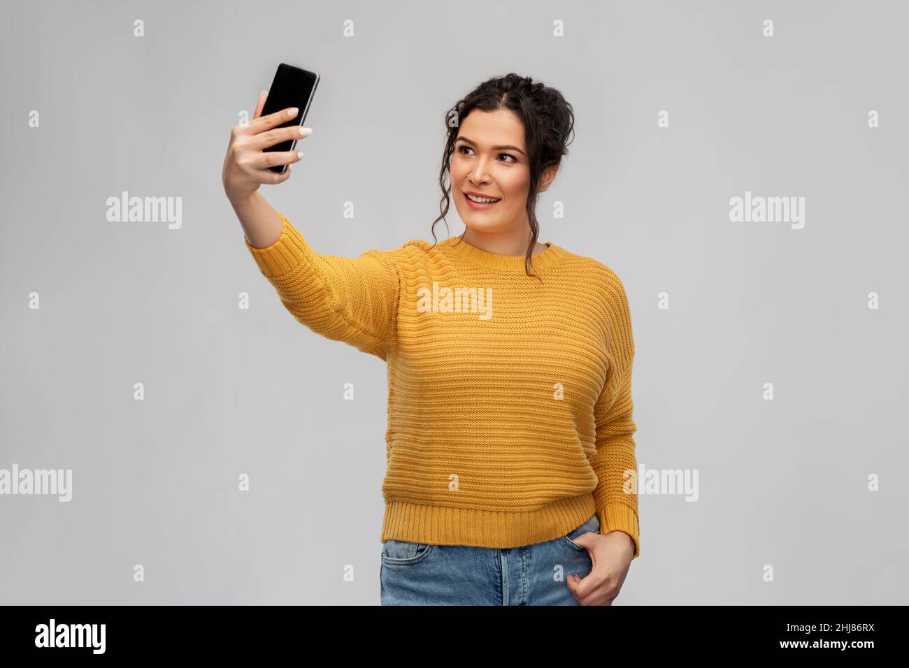 smiling young woman taking selfie by smartphone Stock Photo