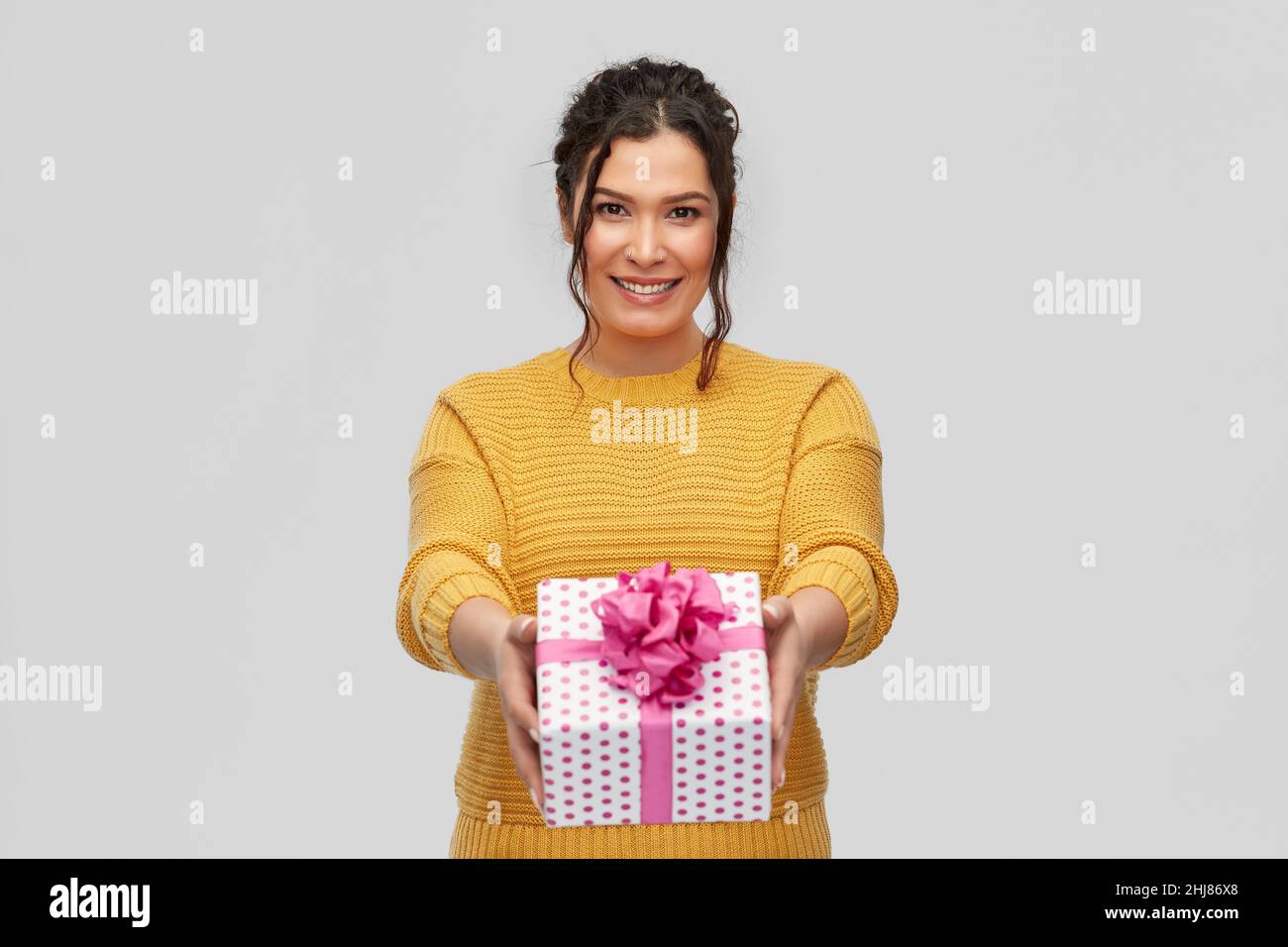 smiling young woman holding gift box Stock Photo