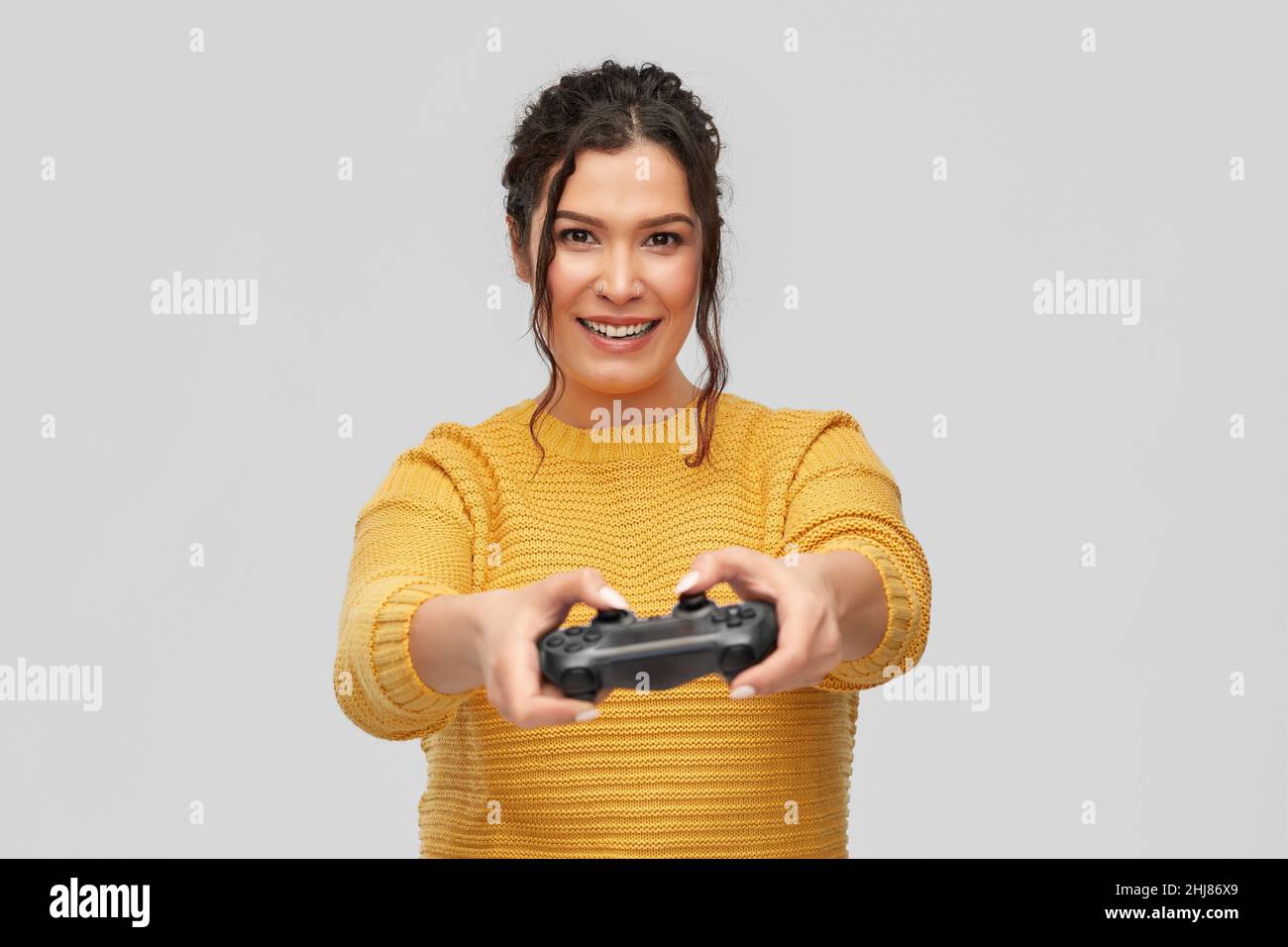 happy young woman with gamepad playing video game Stock Photo
