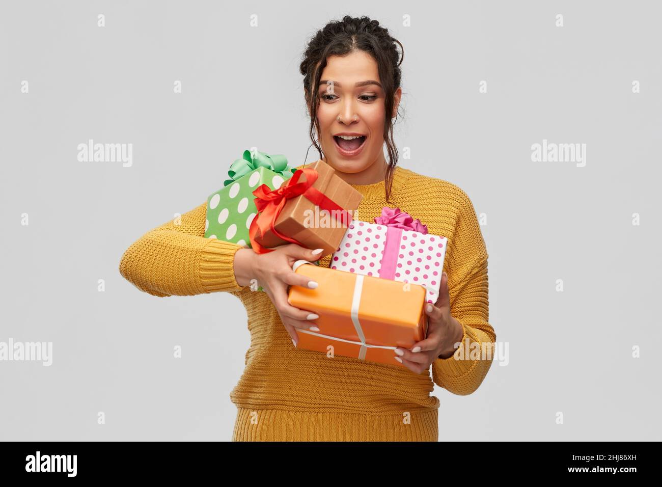 smiling young woman holding gift boxes Stock Photo - Alamy