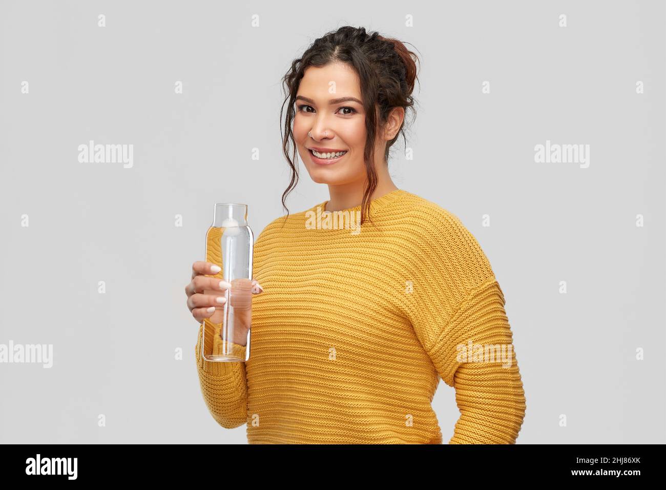 smiling young woman with water in glass bottle Stock Photo