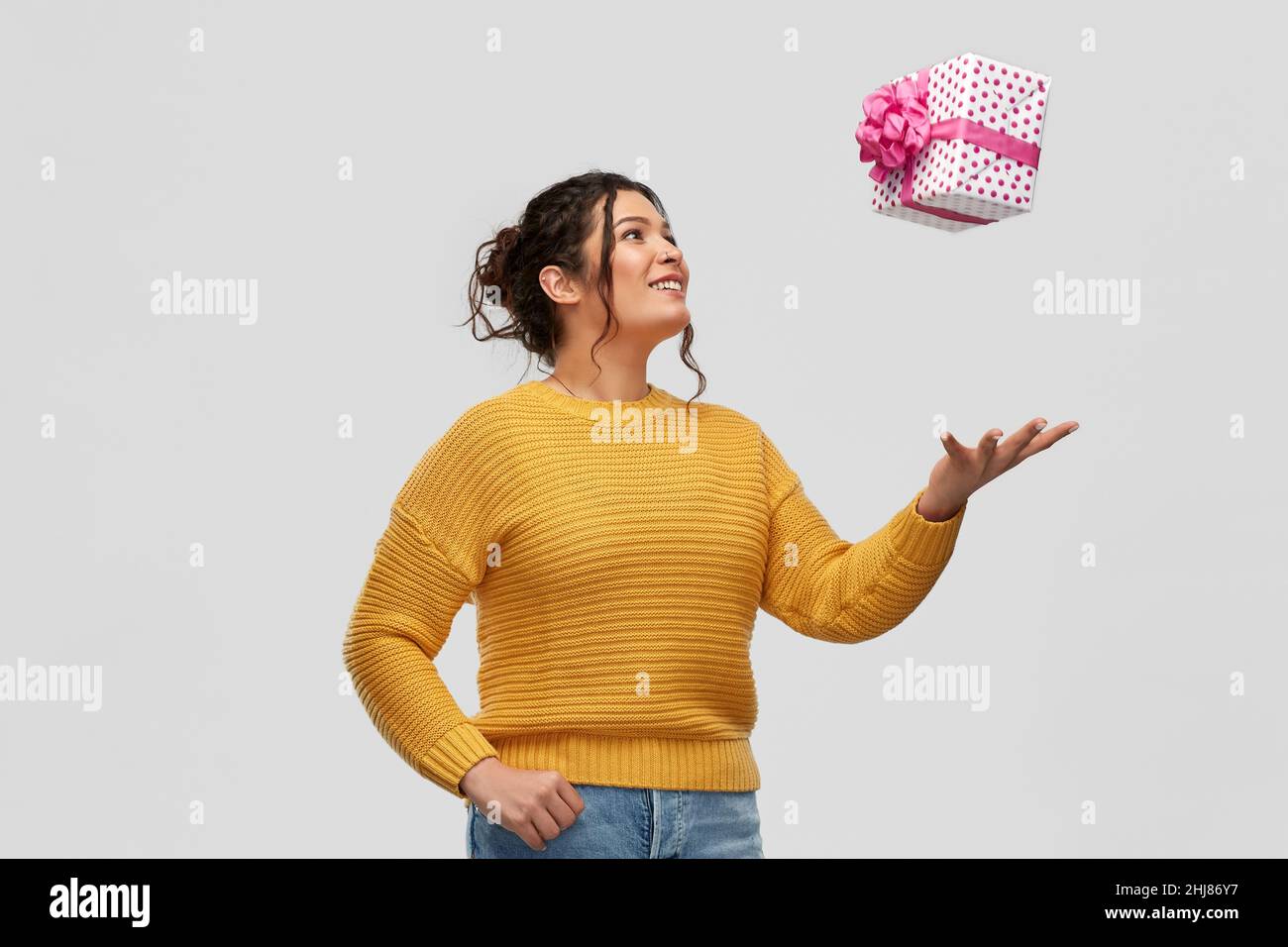 smiling young woman throwing gift box Stock Photo