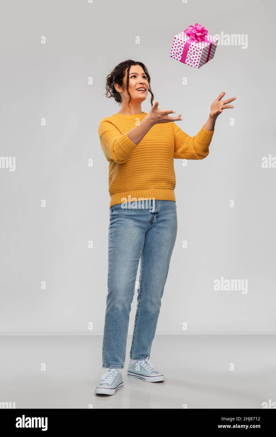 smiling young woman throwing gift box Stock Photo Alamy
