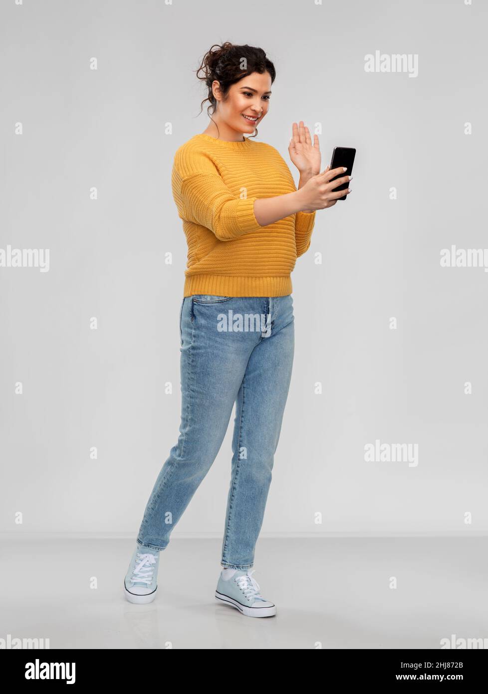 happy young woman having video call on smartphone Stock Photo
