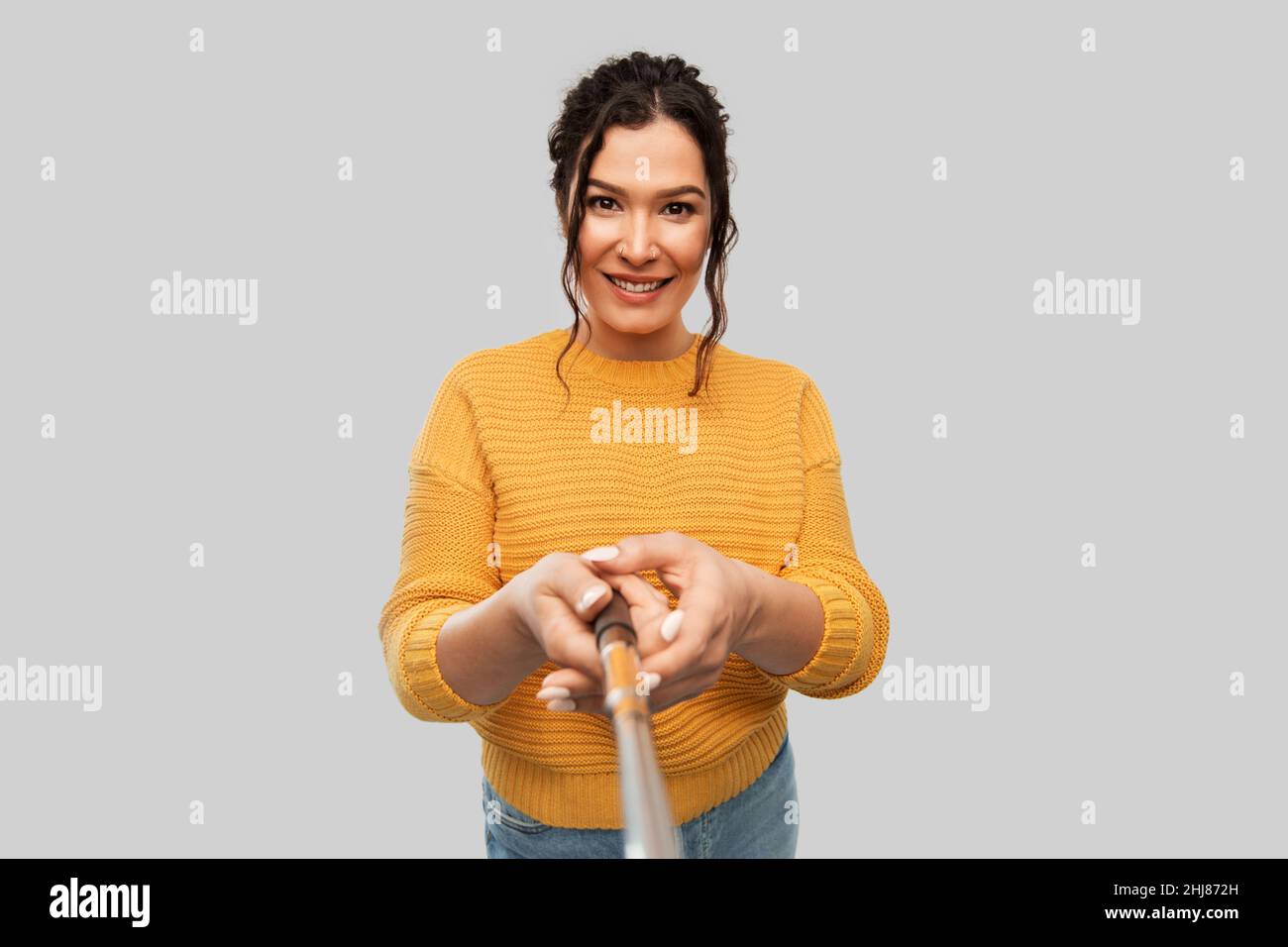 smiling woman taking picture with selfie stick Stock Photo