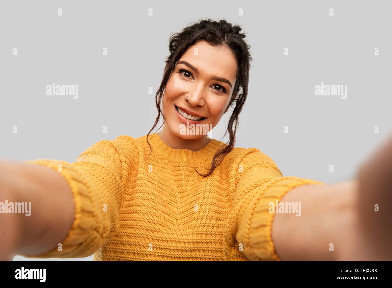 smiling woman with pierced nose taking selfie Stock Photo