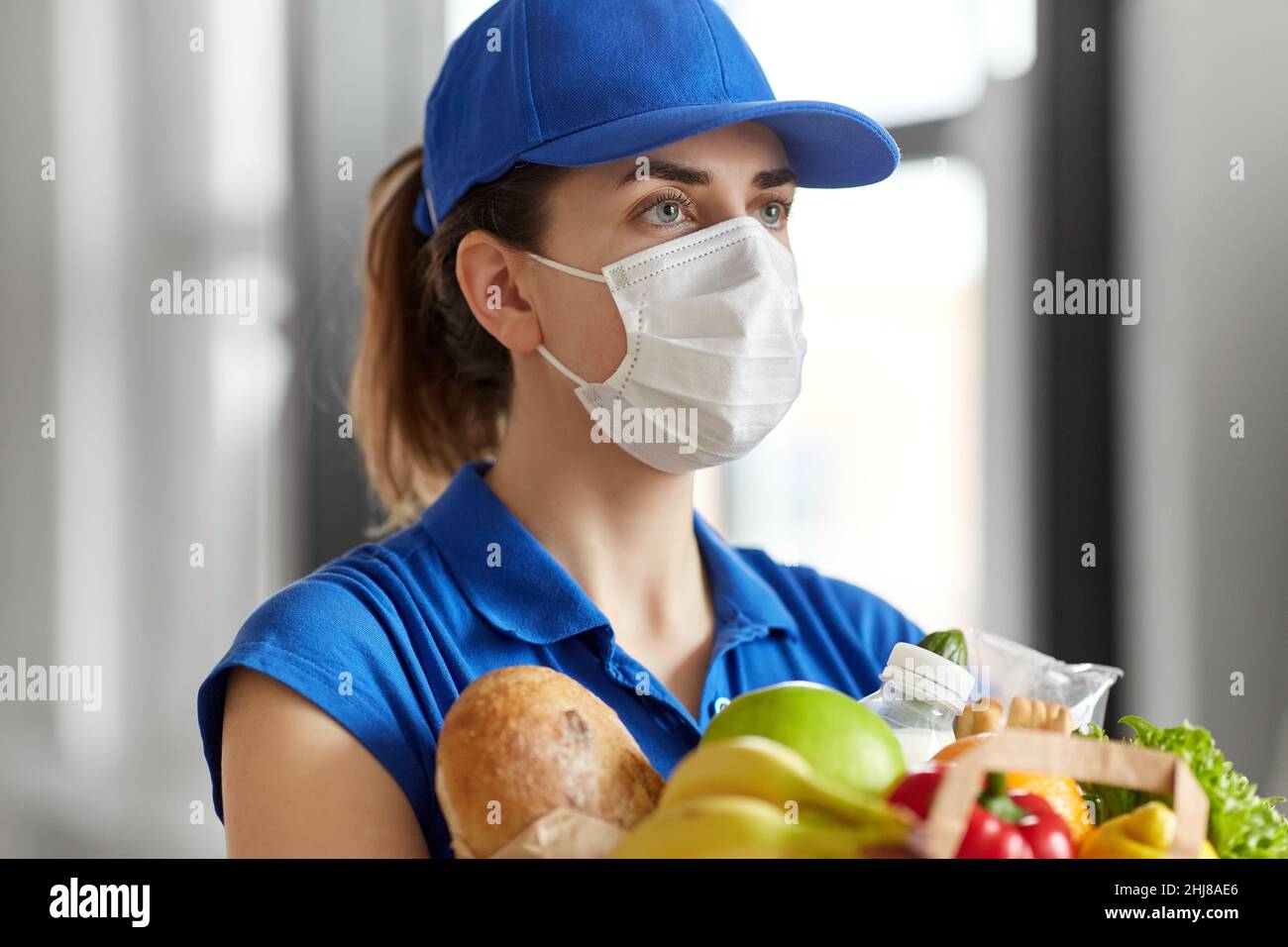delivery woman in face mask with food in paper bag Stock Photo - Alamy