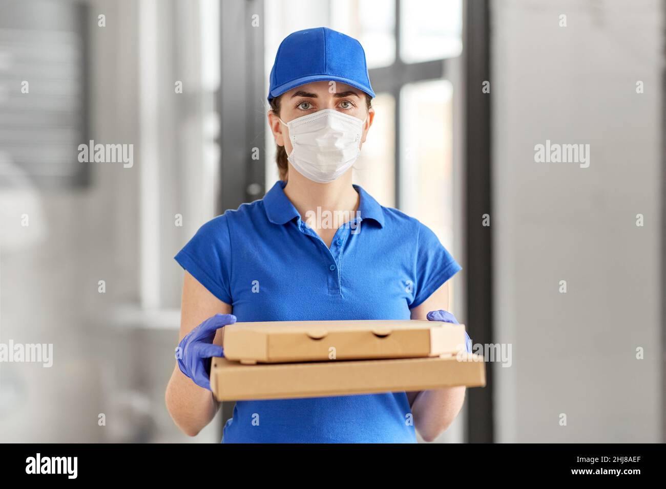 delivery woman in face mask with pizza boxes Stock Photo - Alamy