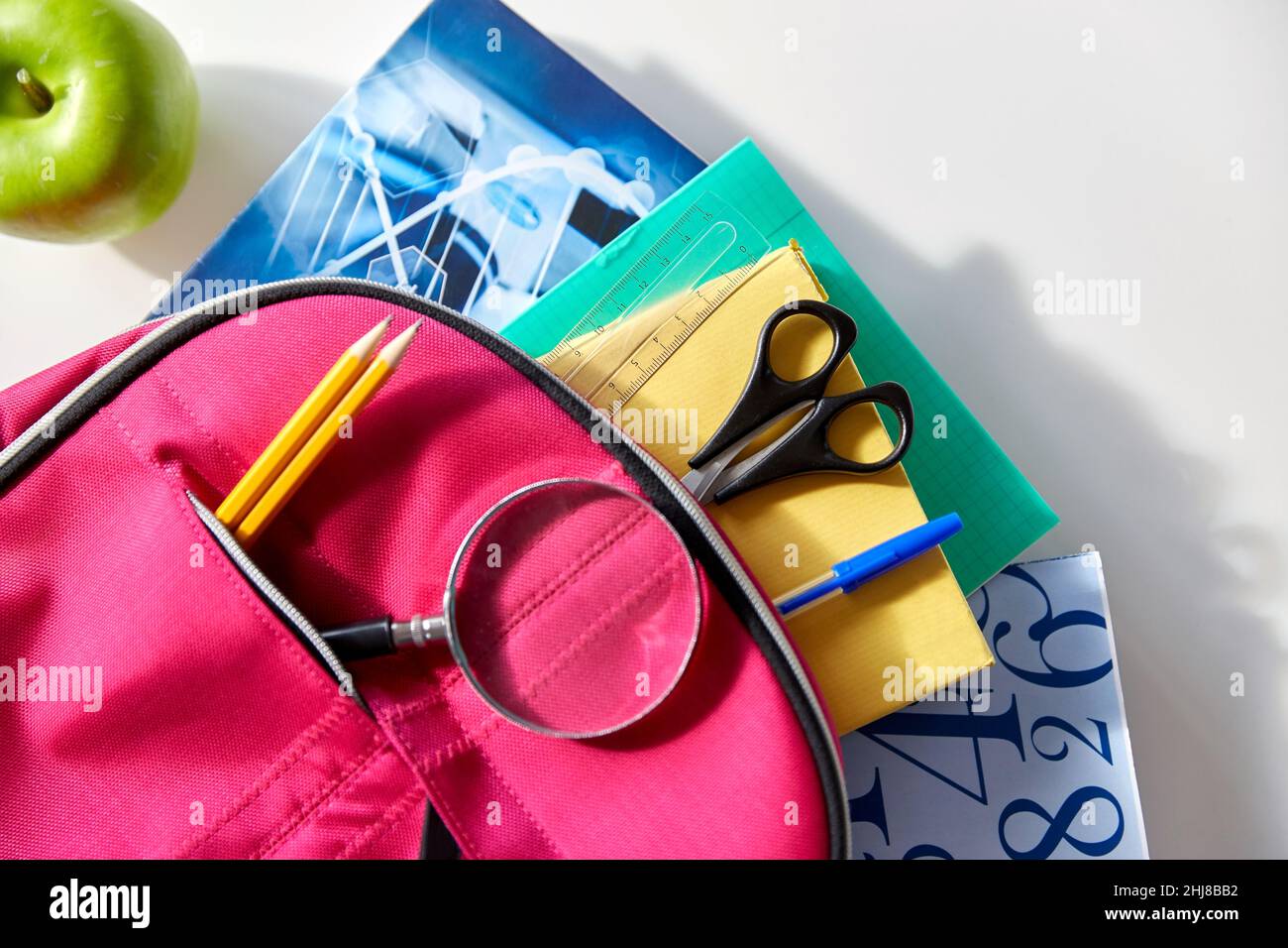 backpack with books, school supplies and apple Stock Photo