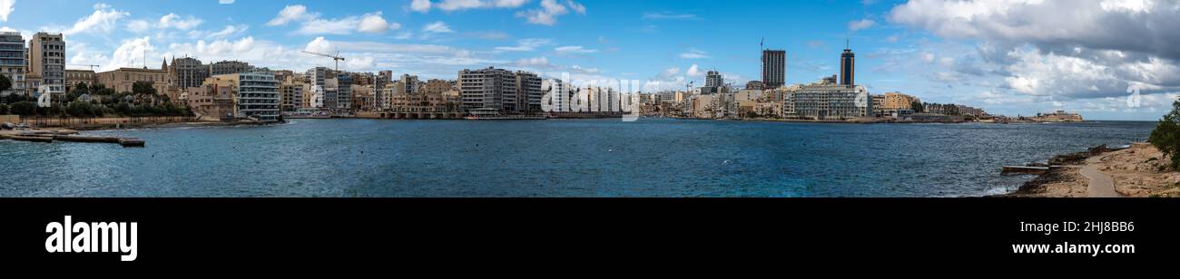 Saint Julian, Malta - 01 07 2022: Extra large panoramic view of the bay and seaside with apartment blocks and restaurants Stock Photo