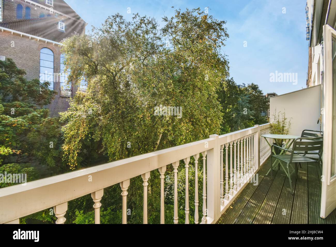 Cozy long narrow balcony with small table and chairs Stock Photo Alamy