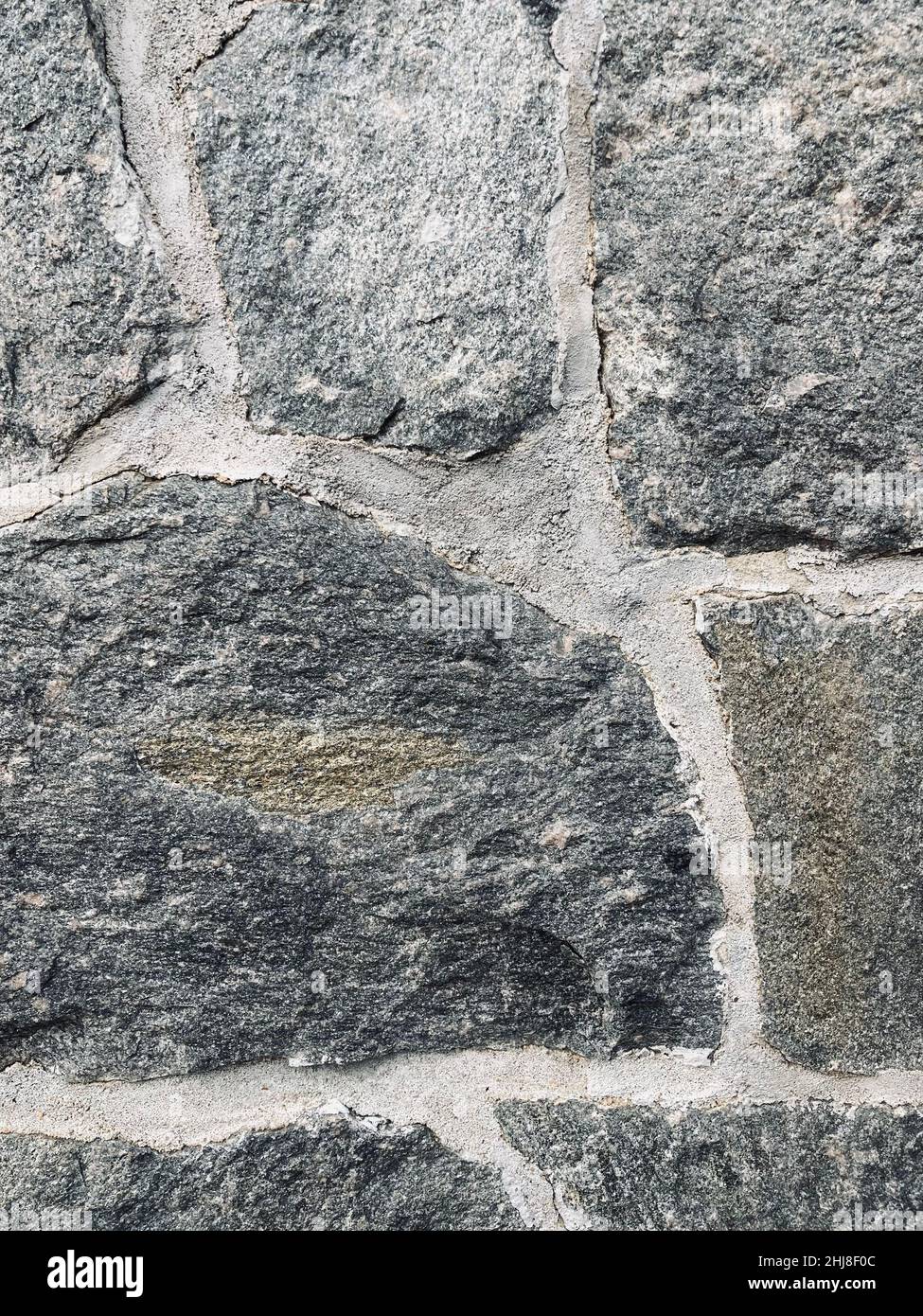 close up of wall made of gray irregular granite stones Stock Photo