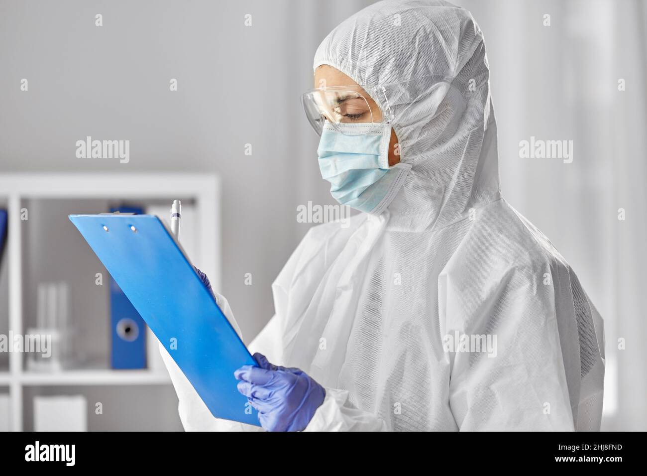 doctor in medical mask and goggles with clipboard Stock Photo