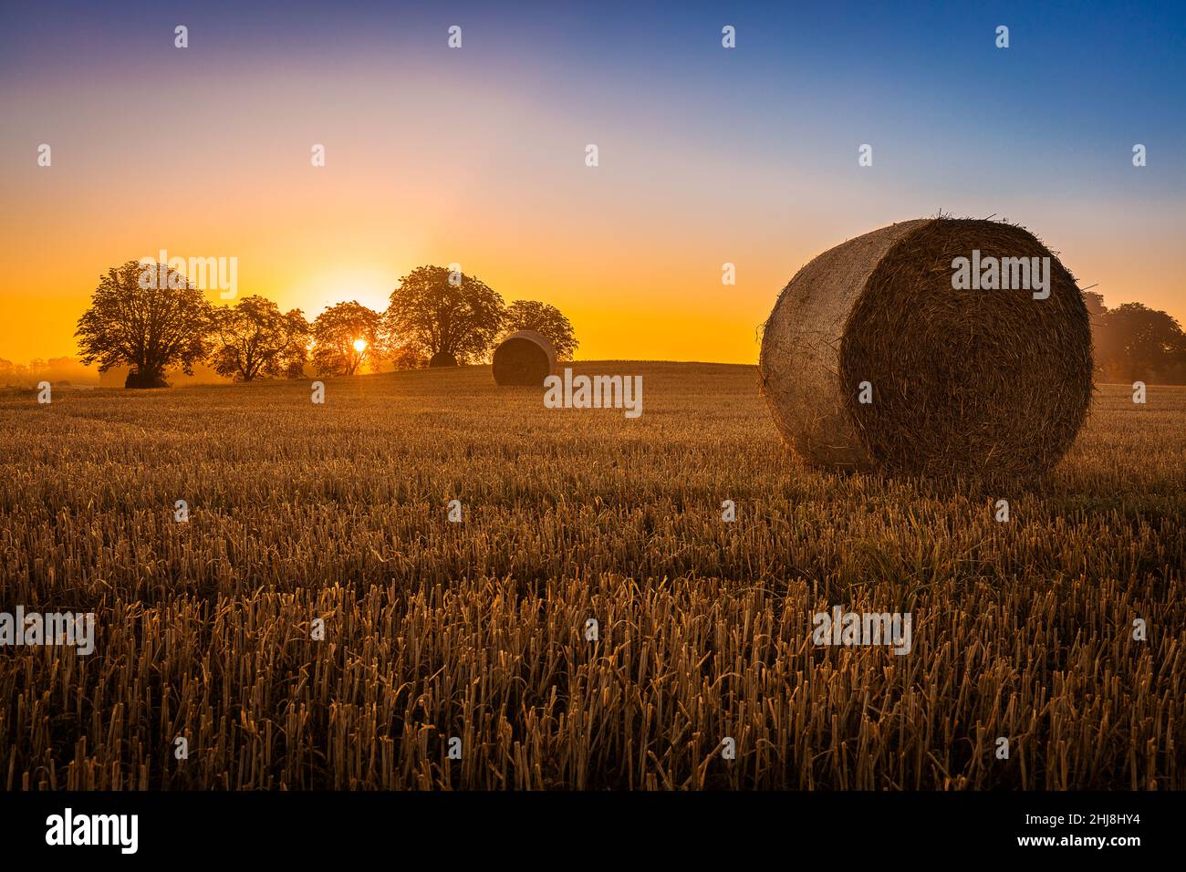 Haystack in Denmark with the sun setting behind Stock Photo