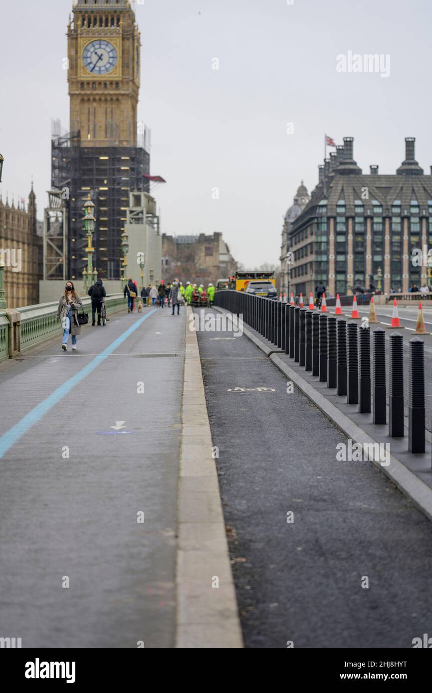London, UK. 27 January 2022. A grey morning in the capital with the recently uncovered Big Ben clocktower above the new bike lane on the bridge Stock Photo