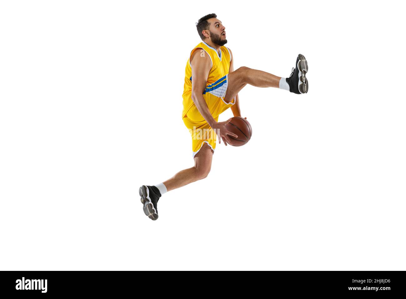 Dynamic portrait of professional basketball player jumping with ball