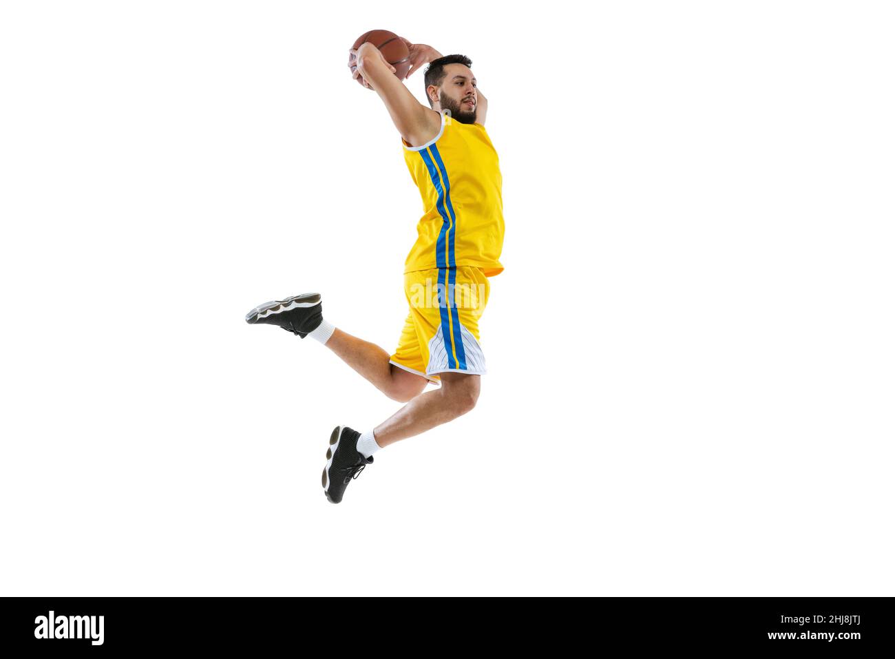 Young sportive man, professional basketball player jumping with ball