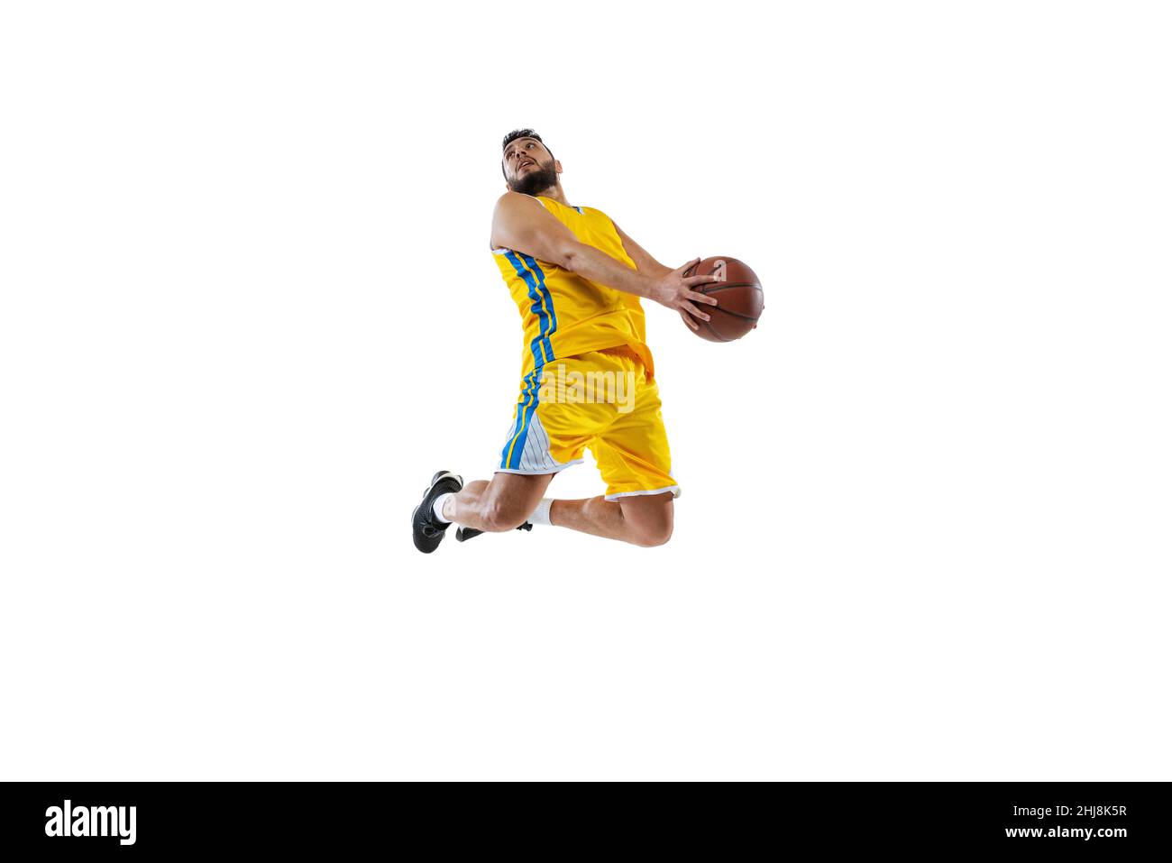 Dynamic portrait of professional basketball player jumping with ball