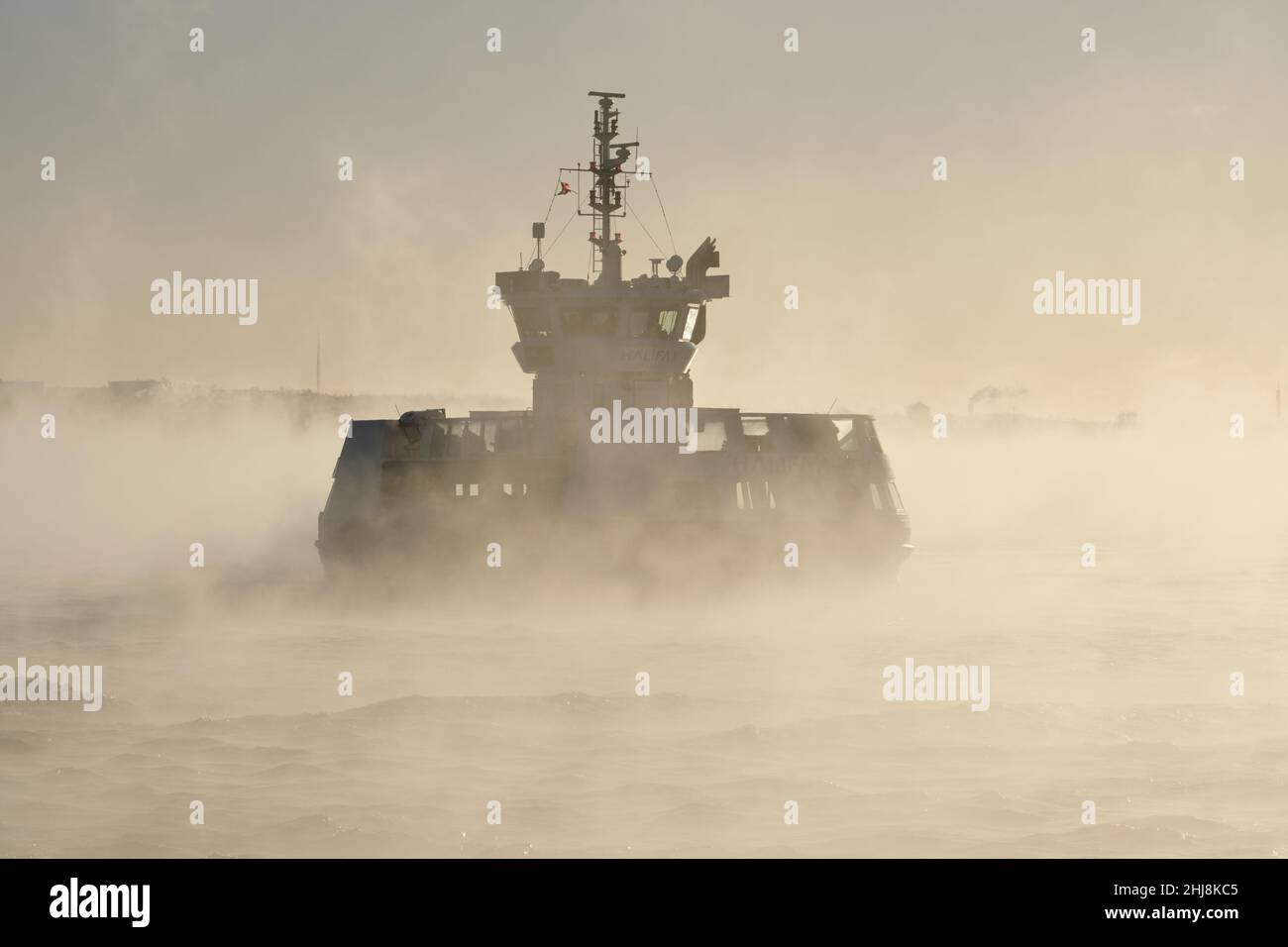 Halifax, Nova Scotia, Canada. January 27th, 2022. As a cold front hits the city overnight, with real feel temperature dropping to -25C, steam fog rises from the harbour early this morning. The Alderny Ferry pulls up into the Halifax station lost in the winter fog. Credit: meanderingemu/Alamy Live News Stock Photo