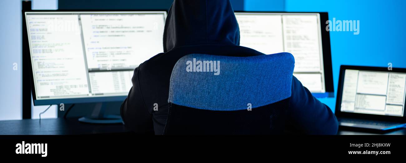 Hacker Using Computer To Write Cyber Security Exploit Software Program Stock Photo