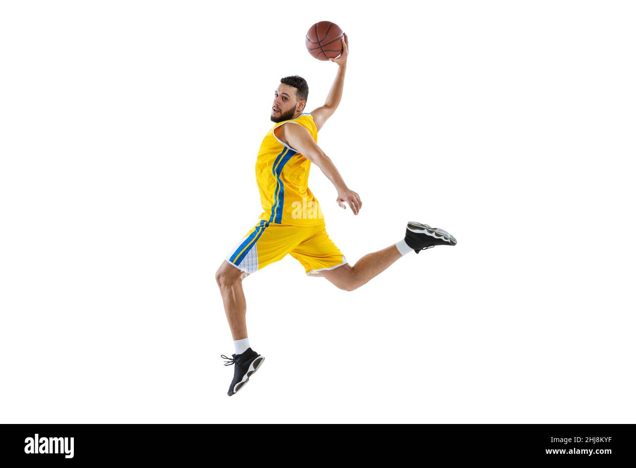 Dynamic portrait of professional basketball player jumping with ball