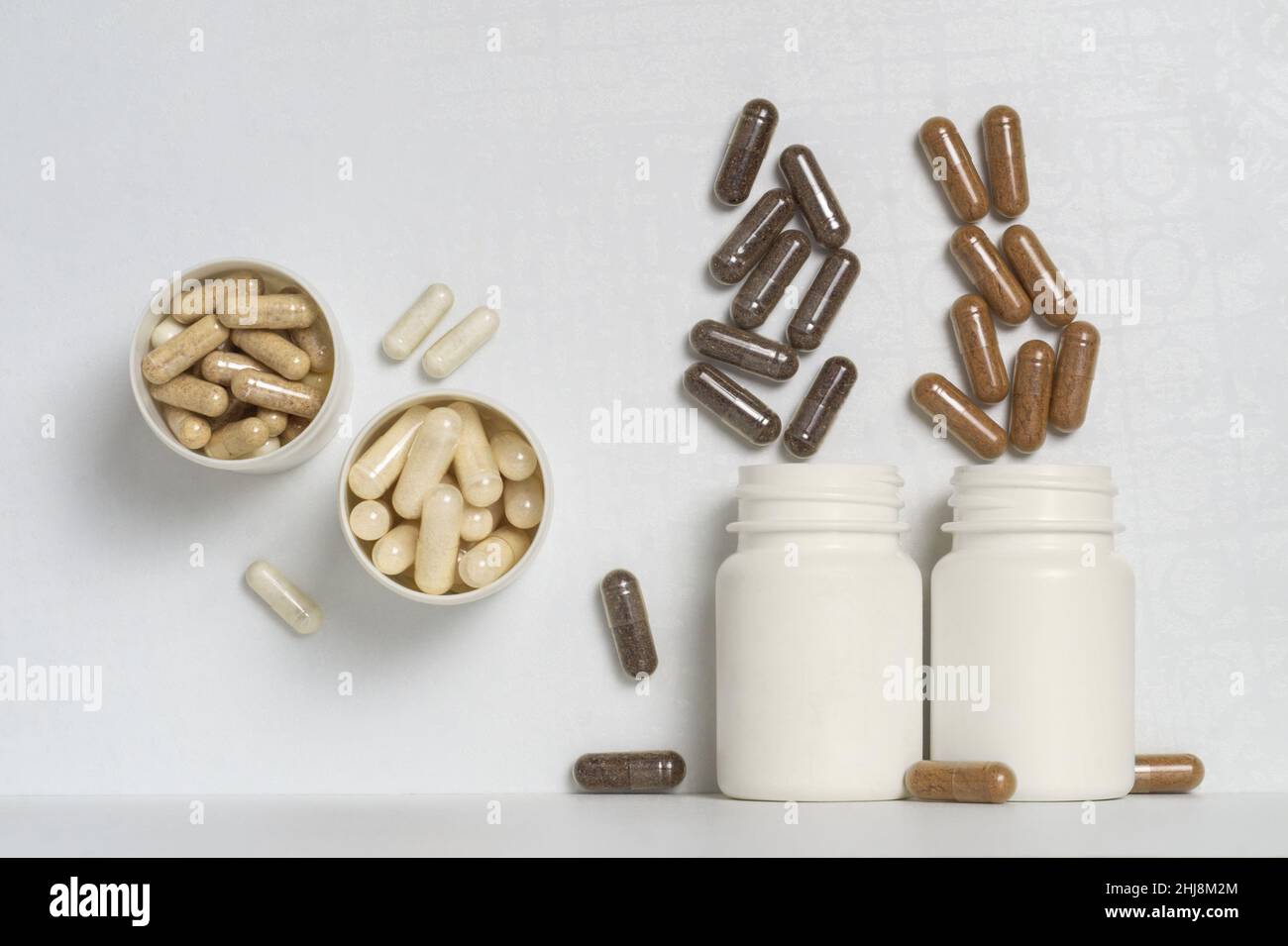 Capsules with dietary supplements or vitamins in white plastic jars in