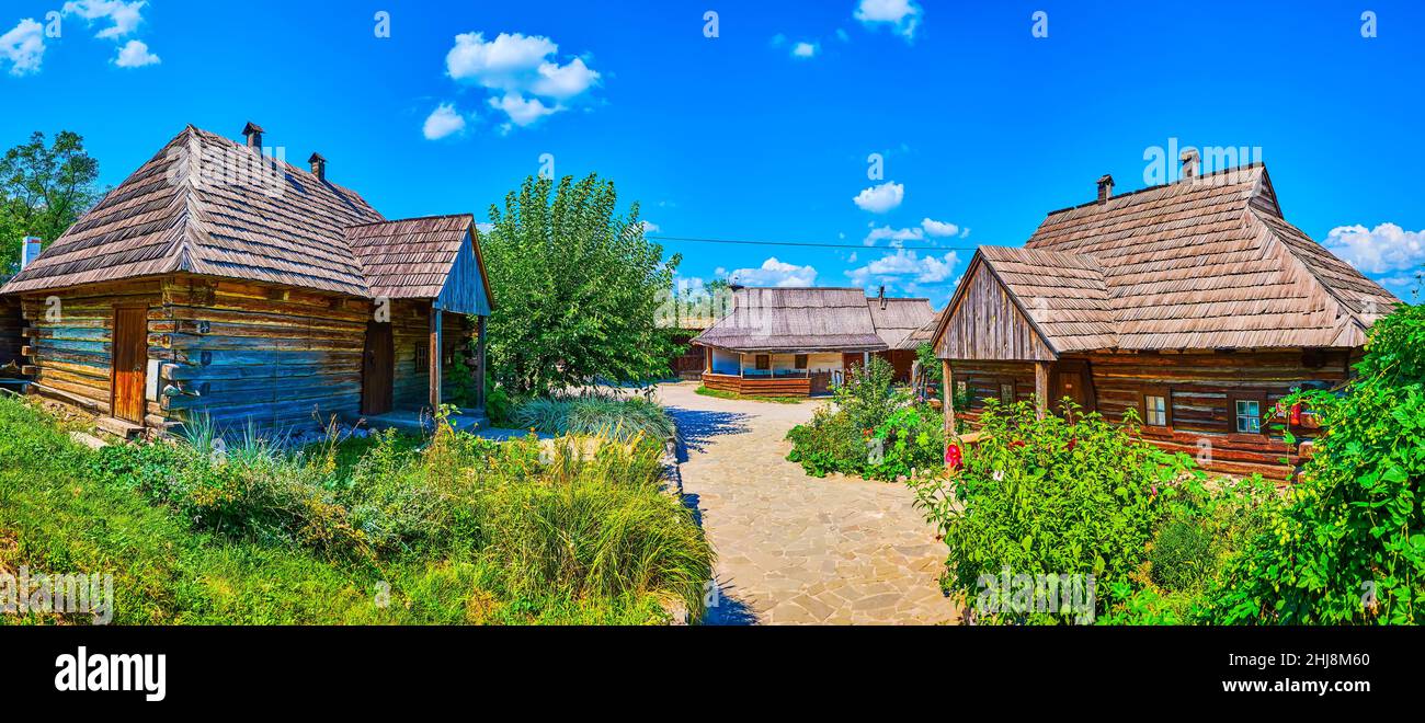 Panorama of the courtyard of Small Kish of historical Zaporizhian Sich scansen with timber houses and small blooming garden, Zaporizhzhia, Ukraine Stock Photo