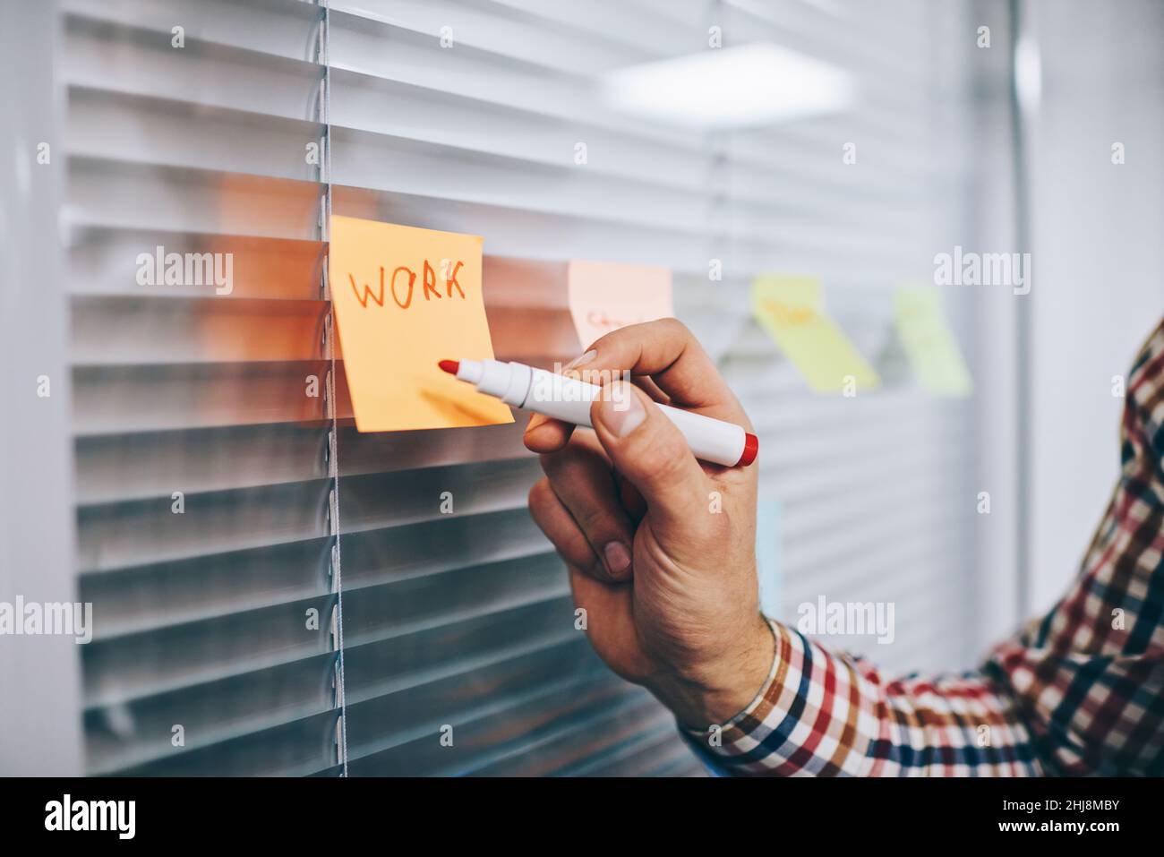 Faceless male employee making notes on sticker Stock Photo