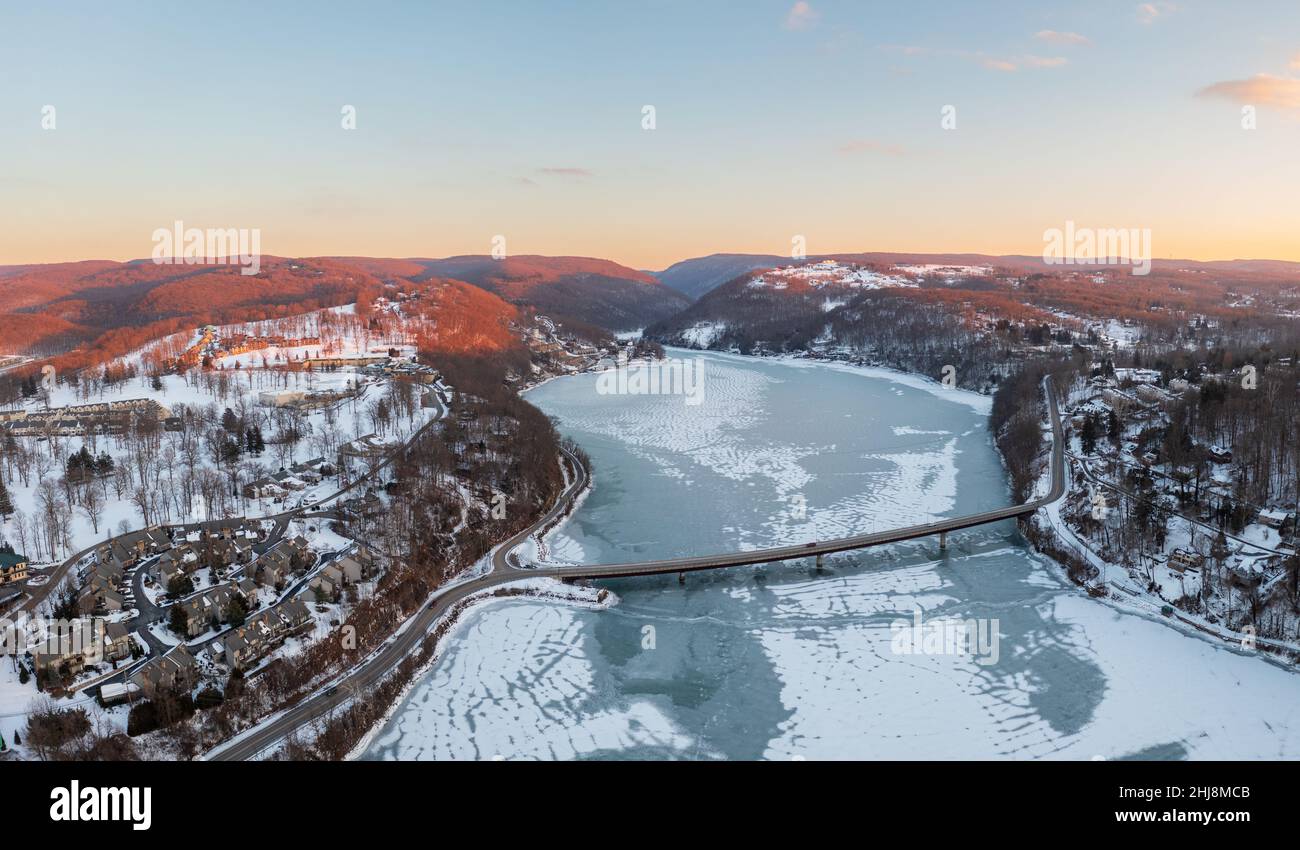 Aerial drone panorama of the frzoen and snow covered Cheat Lake at sunset looking upriver into the gorge near Morgantown, West Virginia Stock Photo