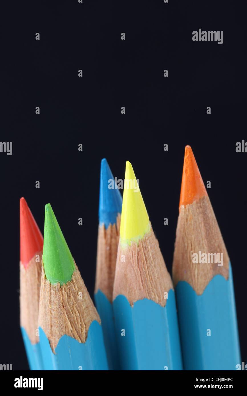 Bright coloured pencils sharpened to fine points on dark background Stock Photo