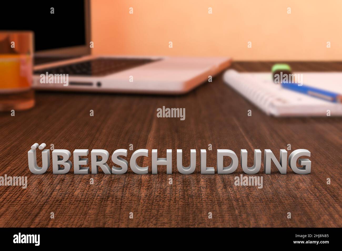Ueberschuldung - german word for over indebtedness - letters on wooden desk with laptop computer and a notebook. 3d render illustration. Stock Photo