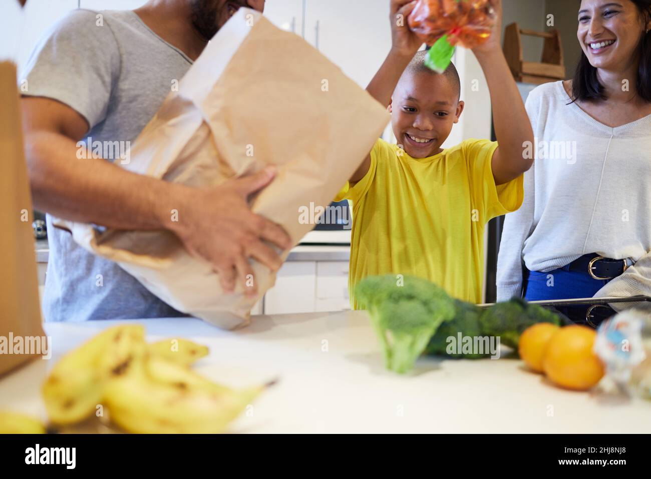 Helping the family to make supper. Shot of a family unpacking the groceries in the kitchen at home. Stock Photo