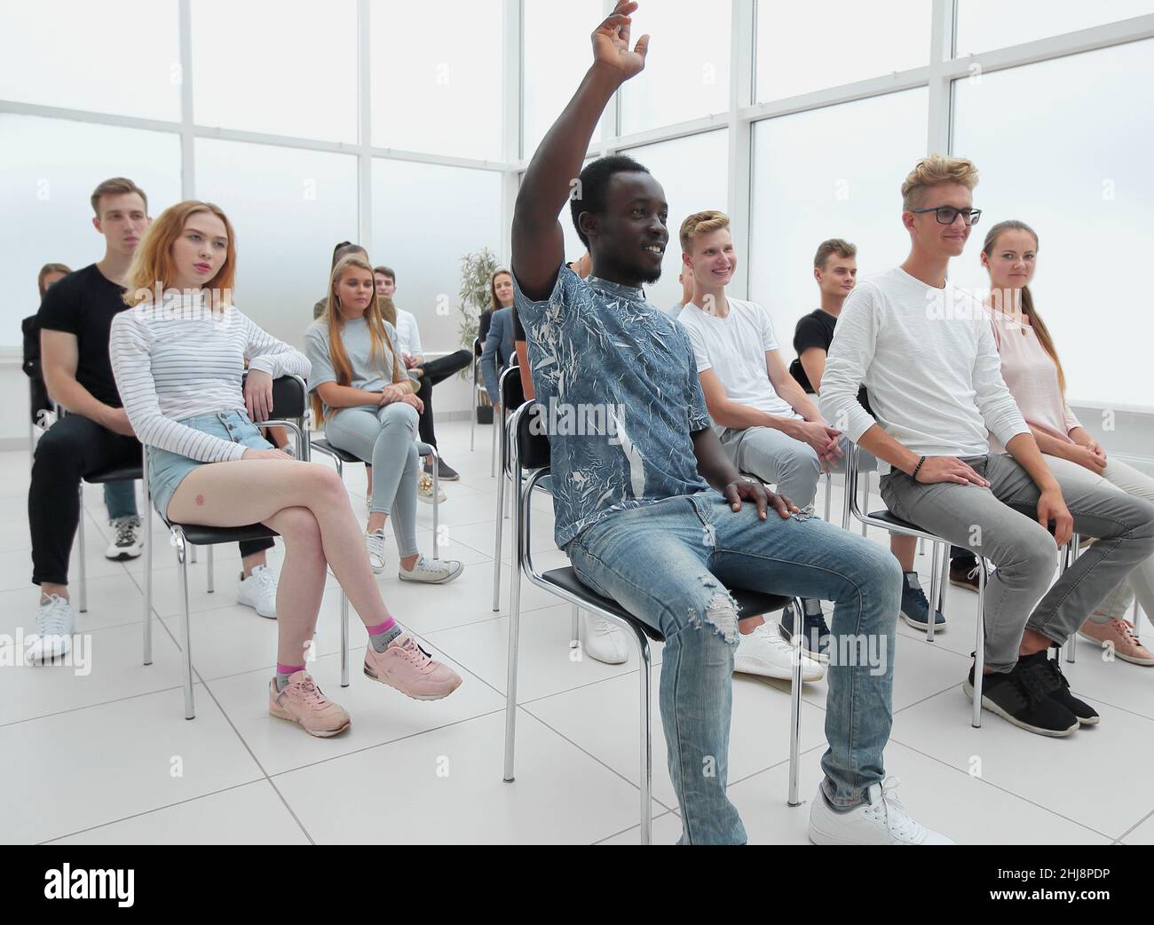 group of diverse young people sitting in a conference room Stock Photo ...
