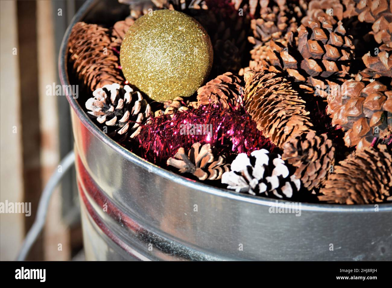 Christmas display with brass candlesticks, greenery, pine cones