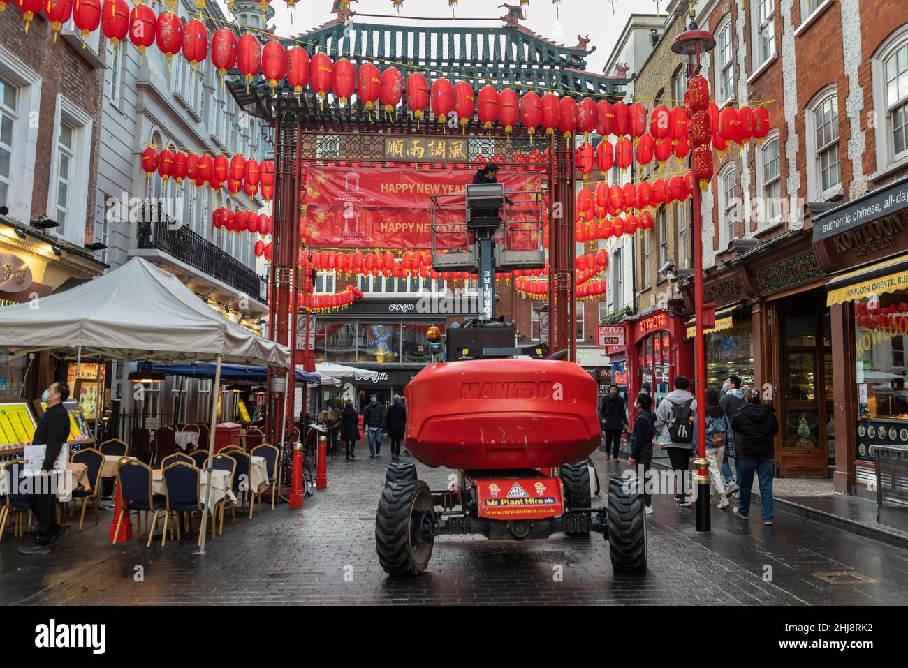 London, UK.  27 January 2022.   A workman on a cherry picker puts up signage on one of the main gates in Chinatown ahead of Chinese New Year.  The Year of the Tiger officially begins on 1 February.  Festivities in Chinatown are scaled back this year to the pandemic.  Credit: Stephen Chung / Alamy Live News Stock Photo