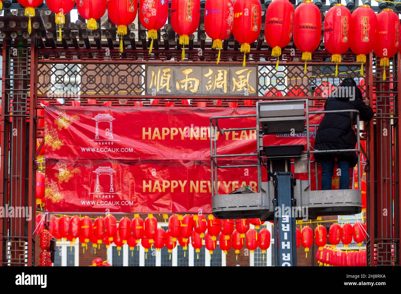 London, UK.  27 January 2022.   A workman on a cherry picker puts up signage on one of the main gates in Chinatown ahead of Chinese New Year.  The Year of the Tiger officially begins on 1 February.  Festivities in Chinatown are scaled back this year to the pandemic.  Credit: Stephen Chung / Alamy Live News Stock Photo