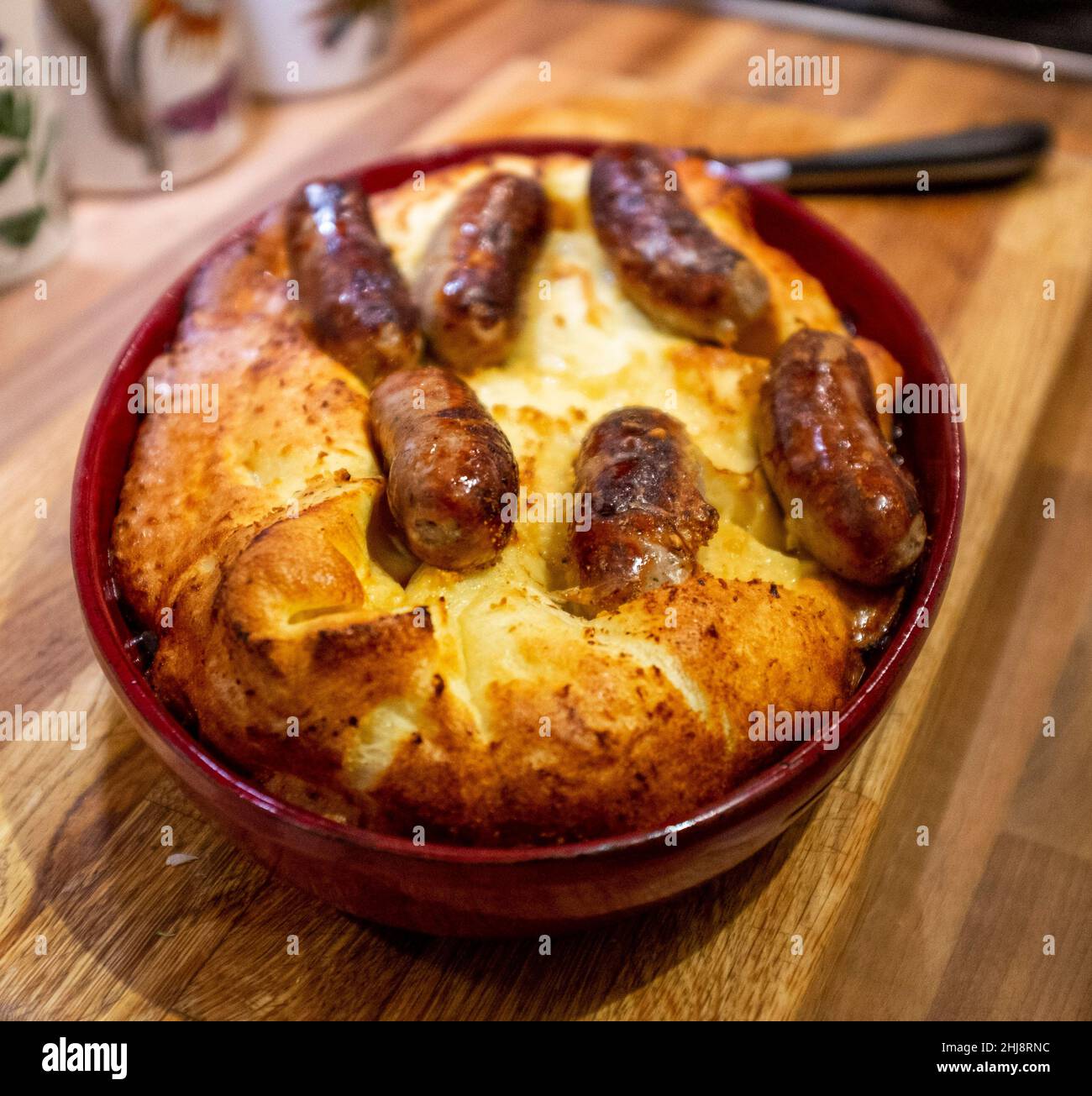 Cooking home made Toad in the Hole or sausages in batter Stock Photo