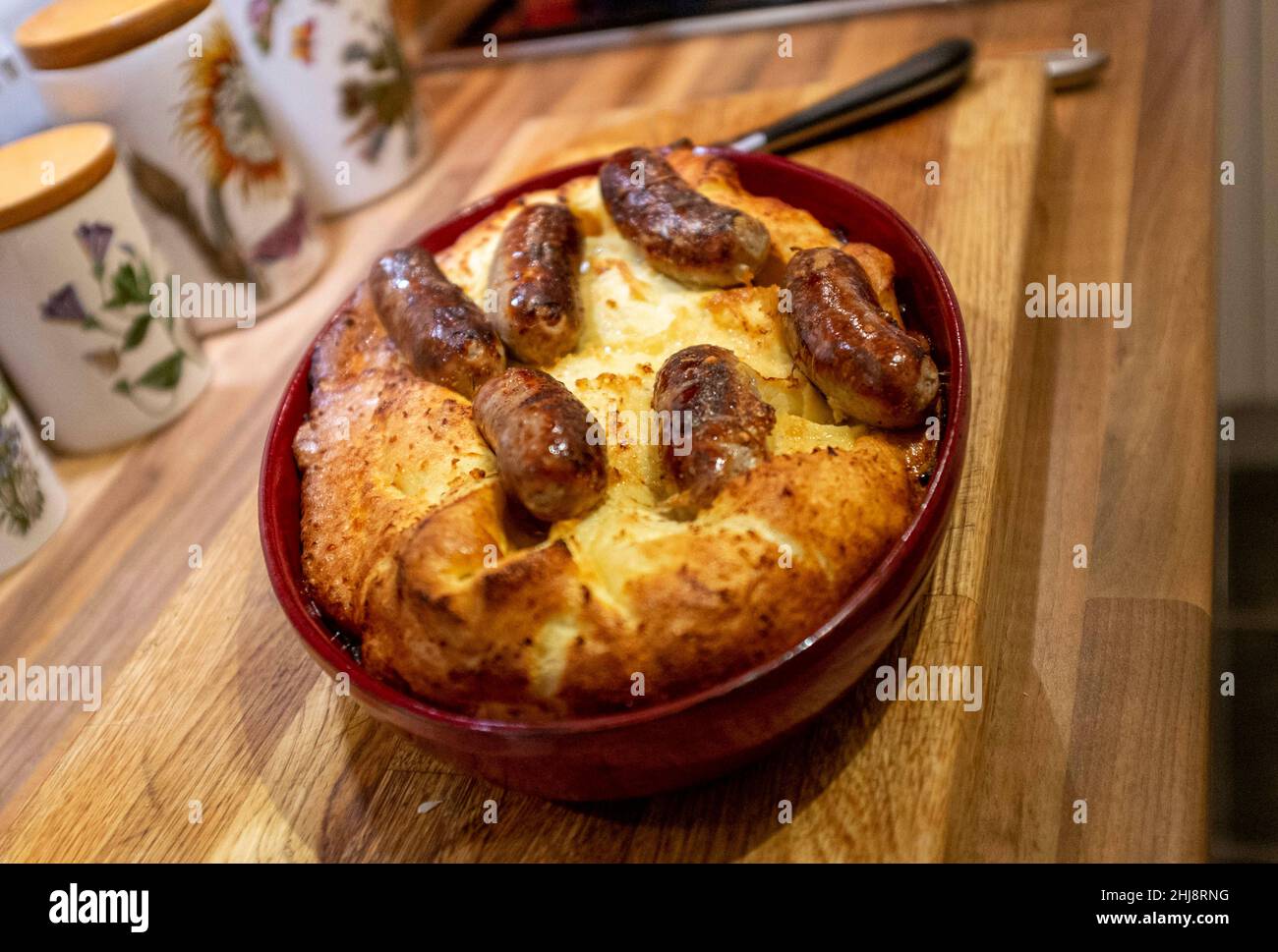 Cooking home made Toad in the Hole or sausages in batter Stock Photo