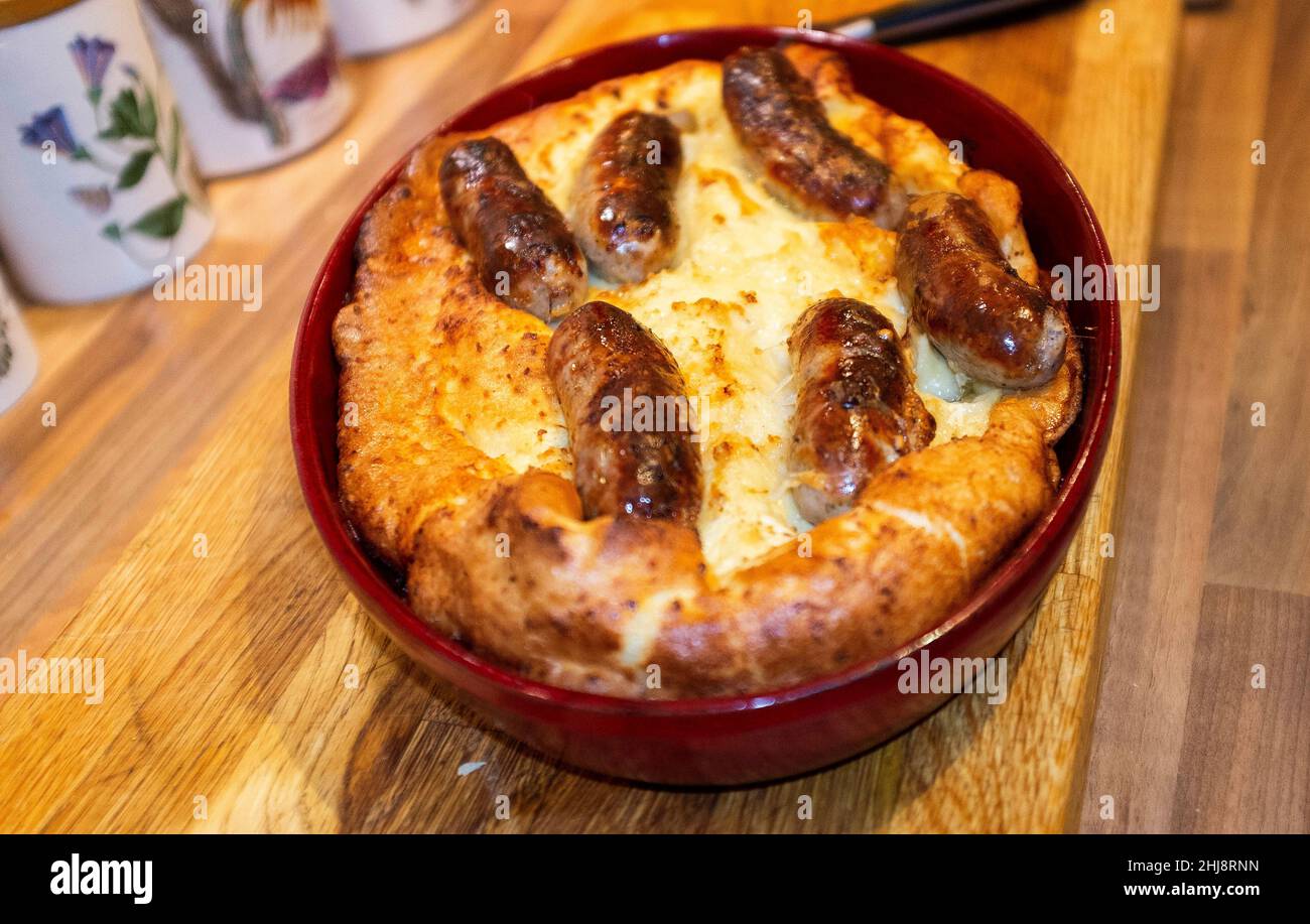 Cooking home made Toad in the Hole or sausages in batter Stock Photo