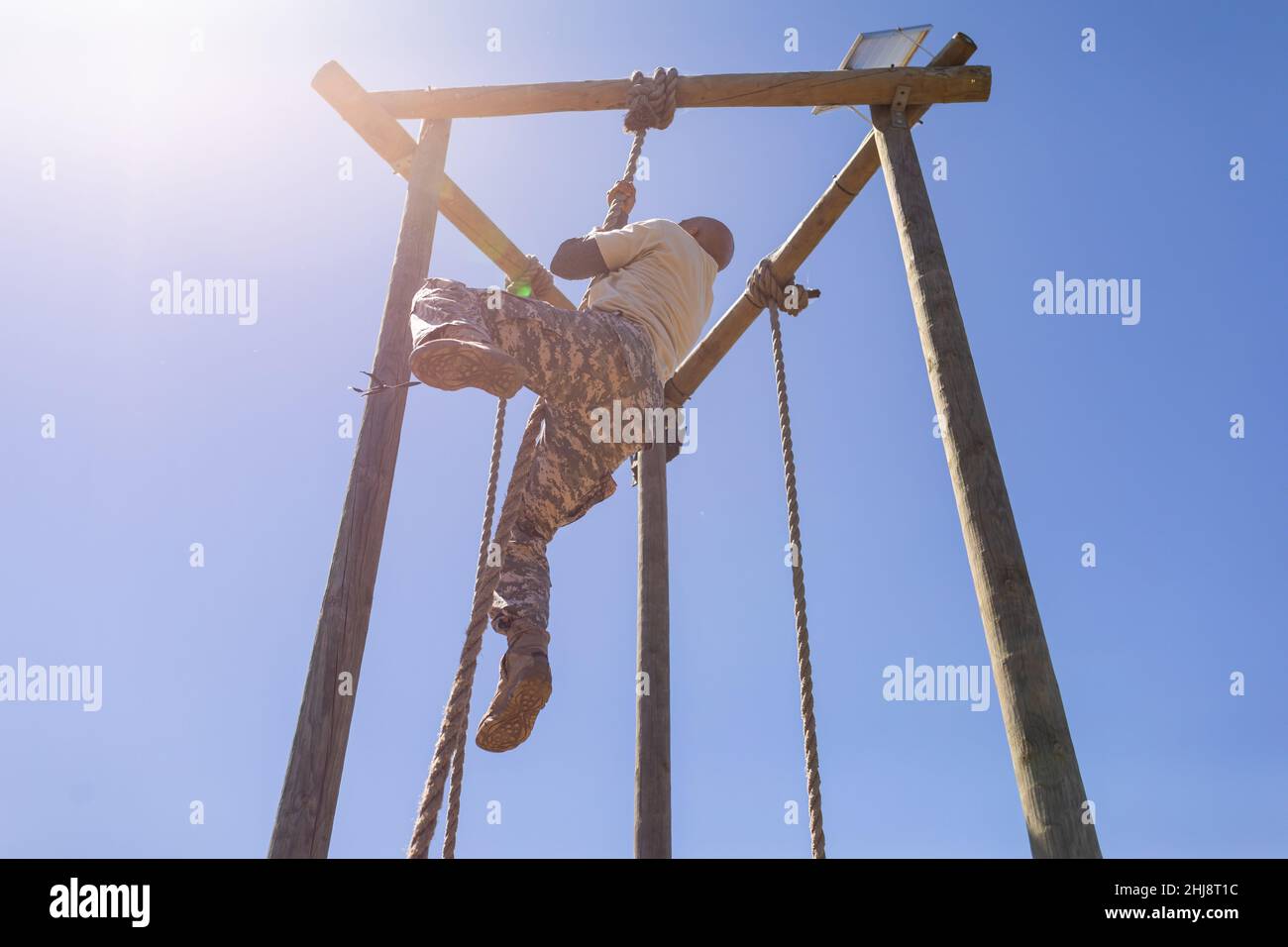 African american male soldier rope climbing during obstacle course at boot camp Stock Photo