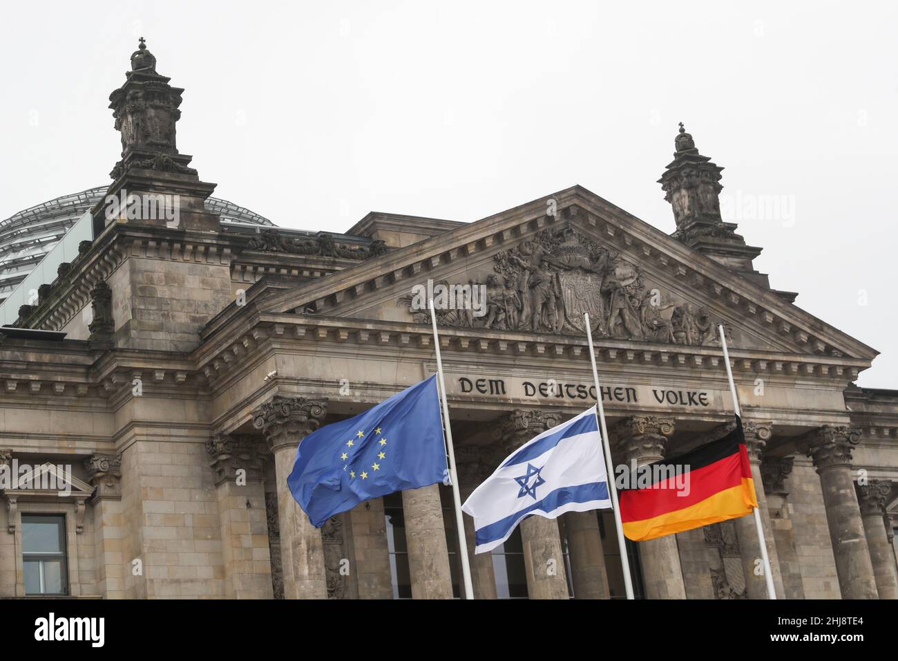 Berlin, Jan. 27. 27th Jan, 1945. Flags of Germany, Israel and European Union fly at half-mast to commemorate victims of Nazism in front of the German Bundestag in Berlin, Germany, on Jan. 27, 2022. The German Bundestag held on Thursday a ceremony marking the 77th anniversary of the liberation of the Auschwitz concentration camp on Jan. 27, 1945. Credit: Shan Yuqi/Xinhua/Alamy Live News Stock Photo