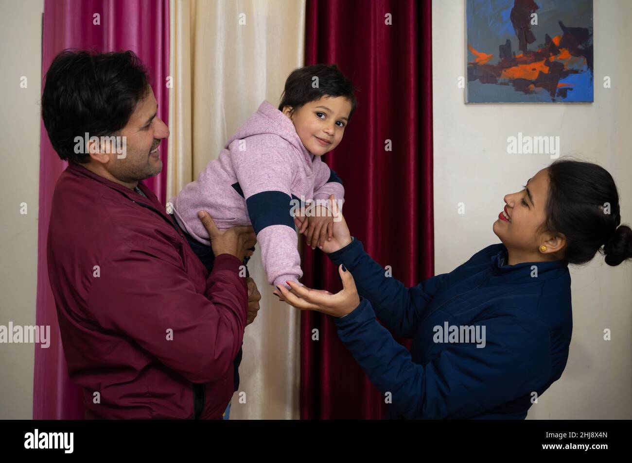 suddenly the love between the child and his parent (mom and dad ) was captured in the camera , this is the way of a child way of expressing love to hi Stock Photo