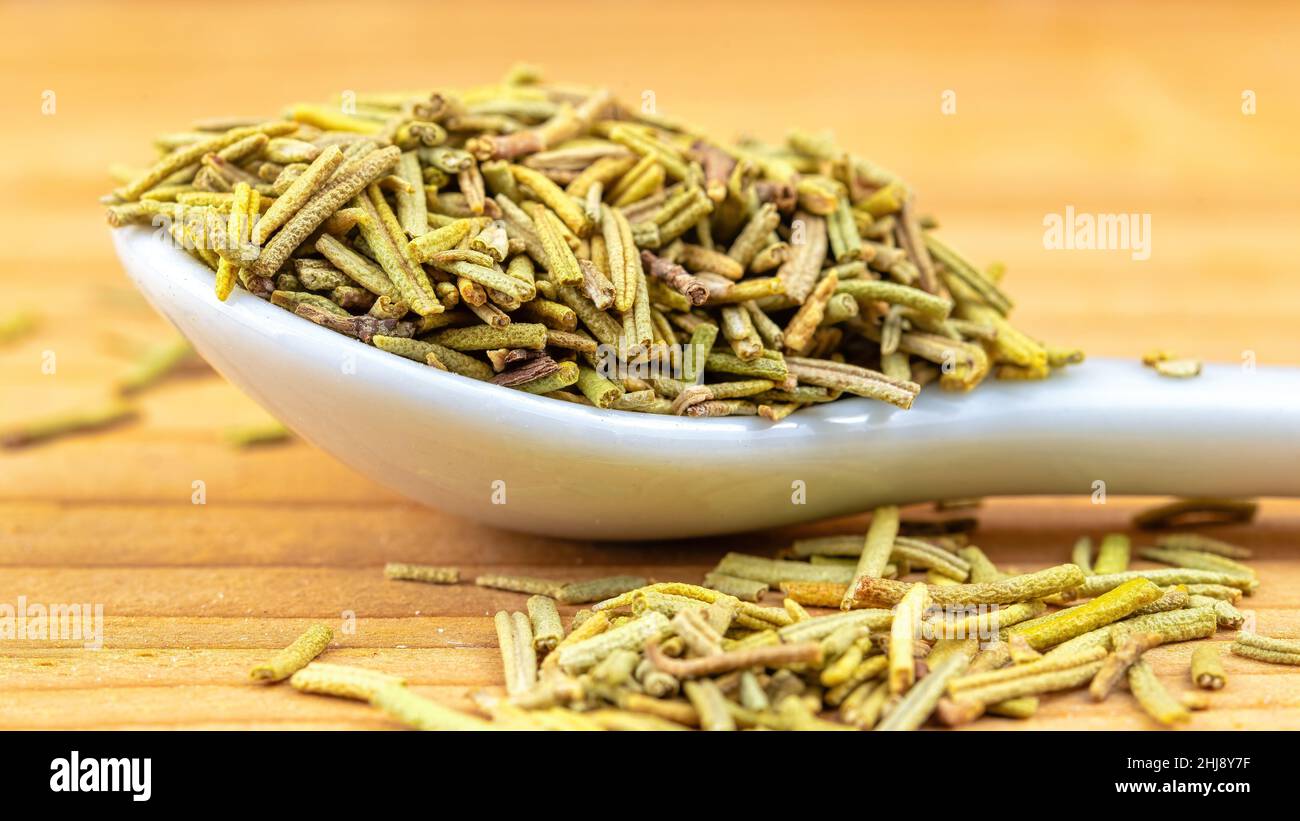 Dry rosemary leaves spice in a small white spoon Stock Photo Alamy